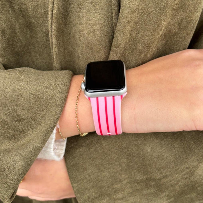 Cherry Stripes Apple Watch strap by Coconut Lane, worn on a wrist with an olive green sleeve.