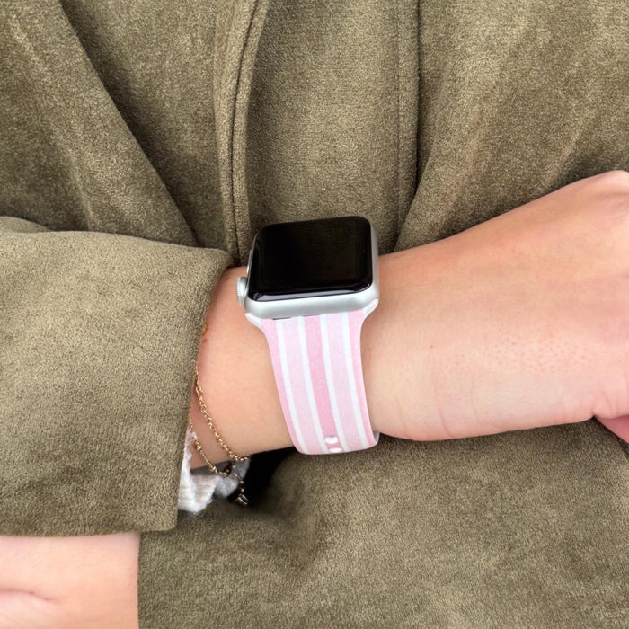 Coconut Lane Powder Stripes Apple Watch strap on a wrist, paired with a tan coat. Hand rests gently on other arm.