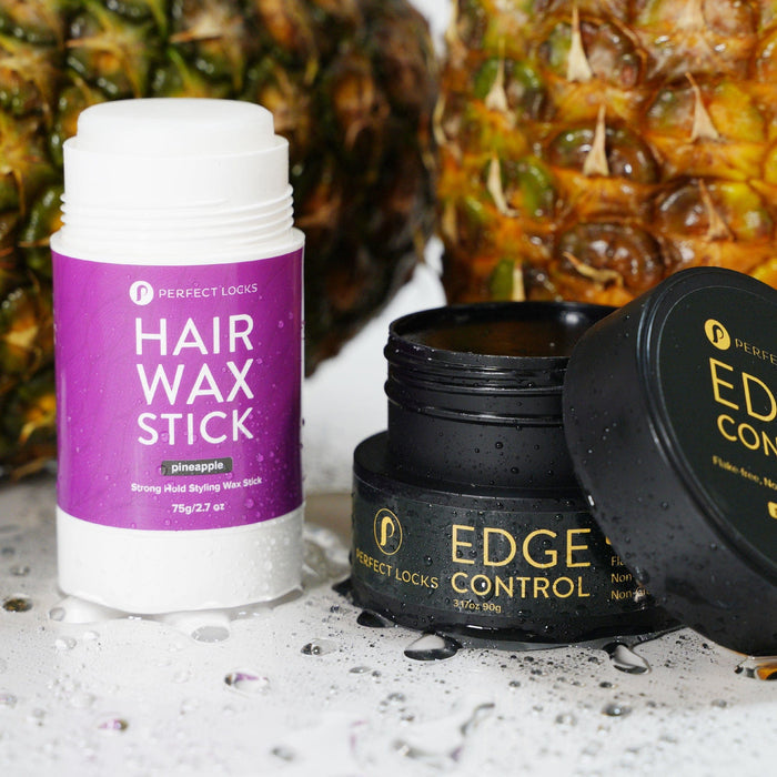 A Perfect Locks pineapple-scented Hair Wax Stick next to an open Edge Control jar, fresh pineapples and water droplets behind.