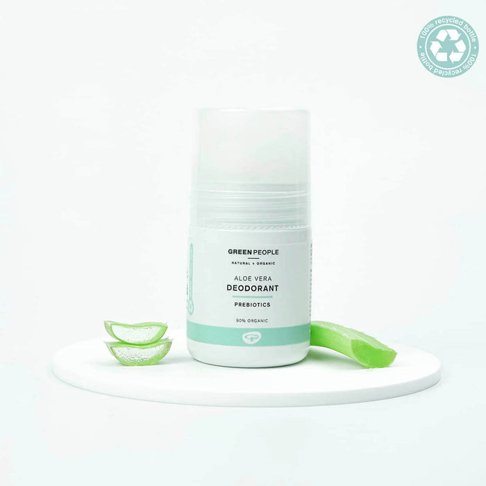 Green People aloe vera deodorant on a white background with slices of aloe vera.