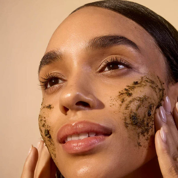 Women applying scrub to her cheeks.