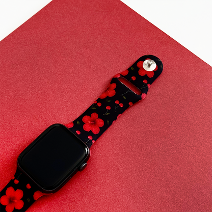 Coconut Lane Cherry Hibiscus Apple Watch strap with floral pattern on a red textured surface, white background.