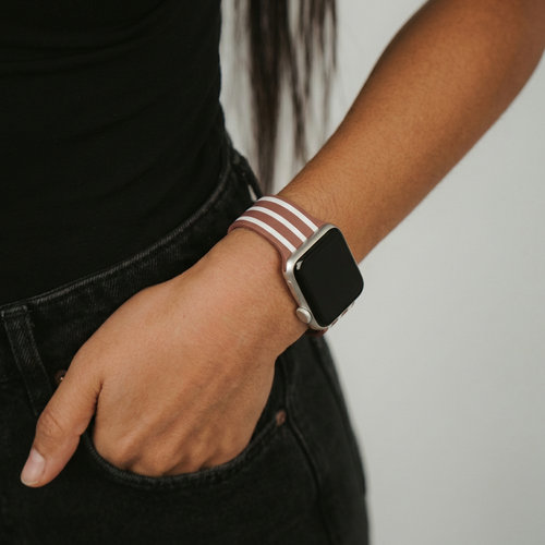 Coconut Lane Chestnut Stripes Apple Watch strap on person dressed in black, hand casually in pocket.