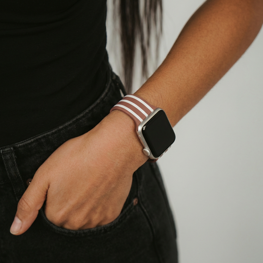 Coconut Lane Chestnut Stripes Apple Watch strap on person dressed in black, hand casually in pocket.