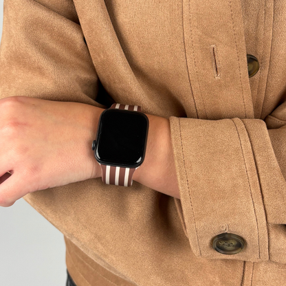 Chestnut striped Apple Watch strap from Coconut Lane on a wrist, paired with a tan coat.