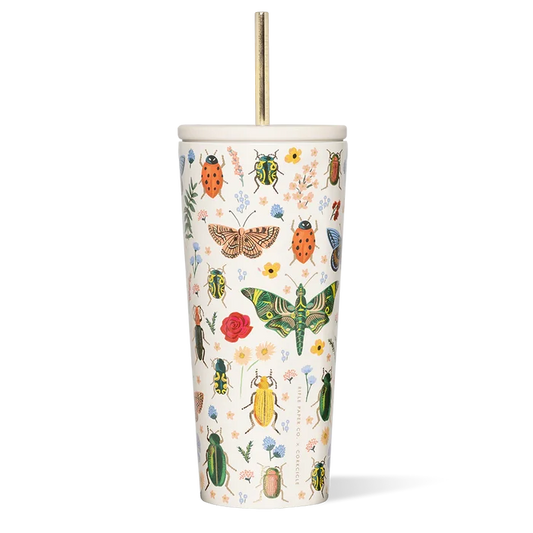 A tall white reusable straw cup with Rifle Paper Co's floral print, featuring various insects and flowers, paired with a gold-colored metal straw.