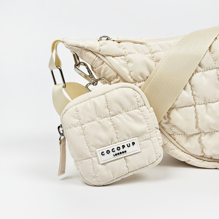 Light blue crescent-shaped crossbody bag with a matching small pouch, both in a smooth finish.