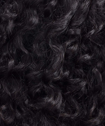 Close-up of Perfect Locks Curly Virgin Hand-Tied Weft with dark, glossy, tightly coiled Remy hair extensions filling the frame.