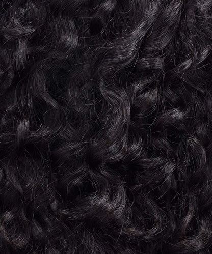 Close-up of Perfect Locks Curly Virgin Machine Weft in Natural Black  with dense, shiny ringlets reflecting light and depth.