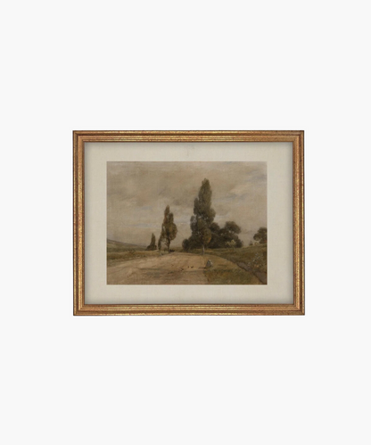 Framed landscape painting depicting a serene countryside with a dirt path, tall trees, and a cloudy sky with a marx gold frame. The muted tones evoke a calm, peaceful mood.  | Wildwood Home Co.