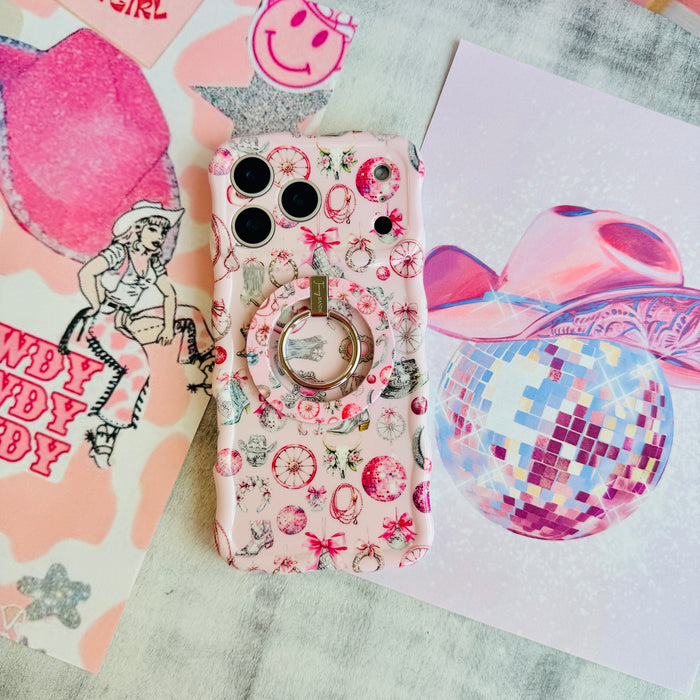 Disco Cowgirl phone grip ring with pink disco balls, cowboy boots, ribbons, and horseshoes on a light pink background compatible with iPhone and Samsung