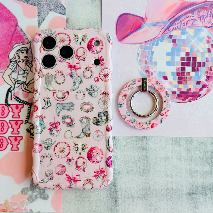 Disco Cowgirl phone grip ring with pink disco balls, cowboy boots, ribbons, and horseshoes on a light pink background compatible with iPhone and Samsung