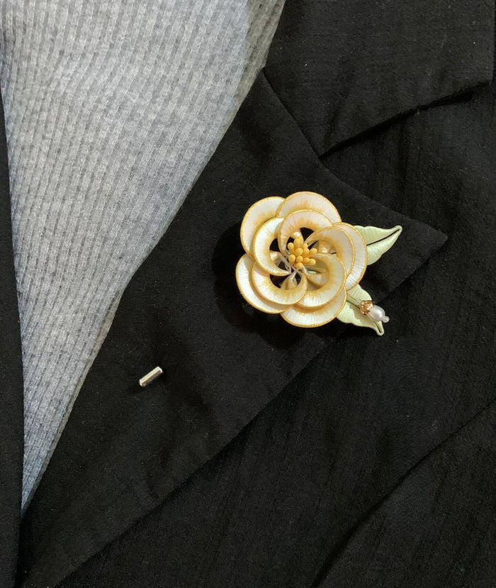 Chanhua handmade white camellia brooch with gold edge petals and yellow stamens, pinned on a black blazer lapel
