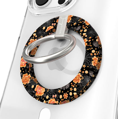 Haunted Blossoms Hold It Fancy MagSafe grip ring close-up on a clear iPhone case, showing the black ring with burnt-orange roses, mushrooms and gold spiderwebs around the silver rotating ring.