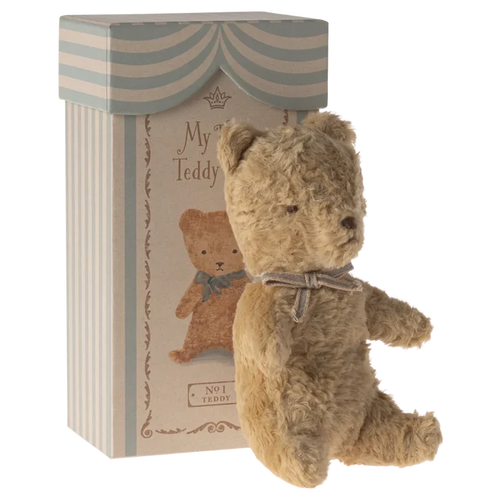 Stuffed teddy bear with a decorative box on a white background