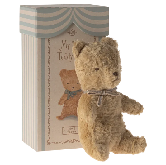 Stuffed teddy bear with a decorative box on a white background
