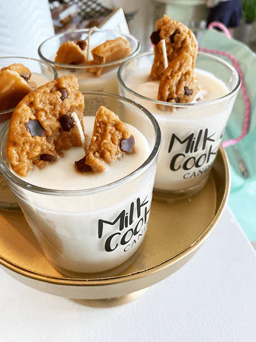 Milk and cookies scented candle in glass jar with realistic cookie toppings on a tray