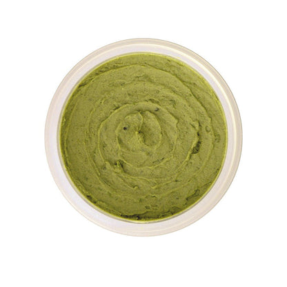 Green organic face mask with botanicals in a clear jar, natural skincare treatment