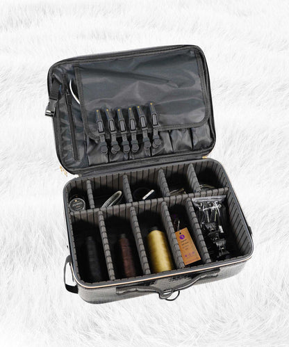 An open black carrying case with adjustable dividers organizes grooming tools, scissors, thread, clippers, comb, and a bottle on white.