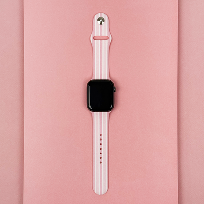 Coconut Lane Apple Watch strap with powder stripes pattern on a pink background.