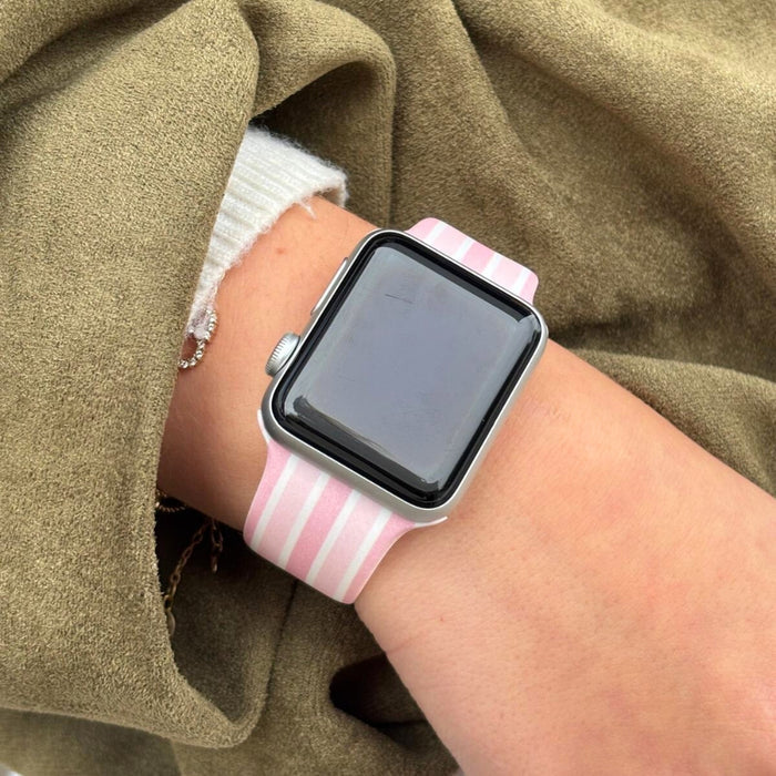 Pink and white Coconut Lane Powder Stripes Apple Watch strap worn over a green sleeve.