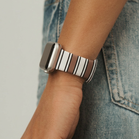 Coconut Lane Retro Stripes Apple Watch strap with colorful stripes, worn by someone in blue jeans.