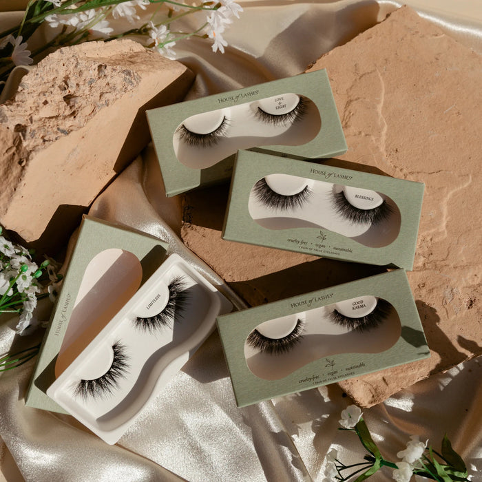 Three green Secret Collection Custom 3-Pack eyelash boxes displayed on a rocky backdrop.