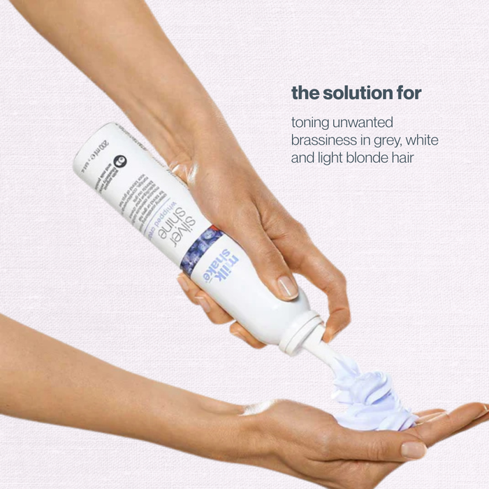 Hand holding a bottle of hair product with text about toning unwanted brassiness in hair color.