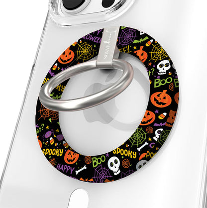Spooky Hold It Fancy MagSafe grip ring shown on a clear iPhone case, black ring covered in orange pumpkins, white skulls and spiderwebs.