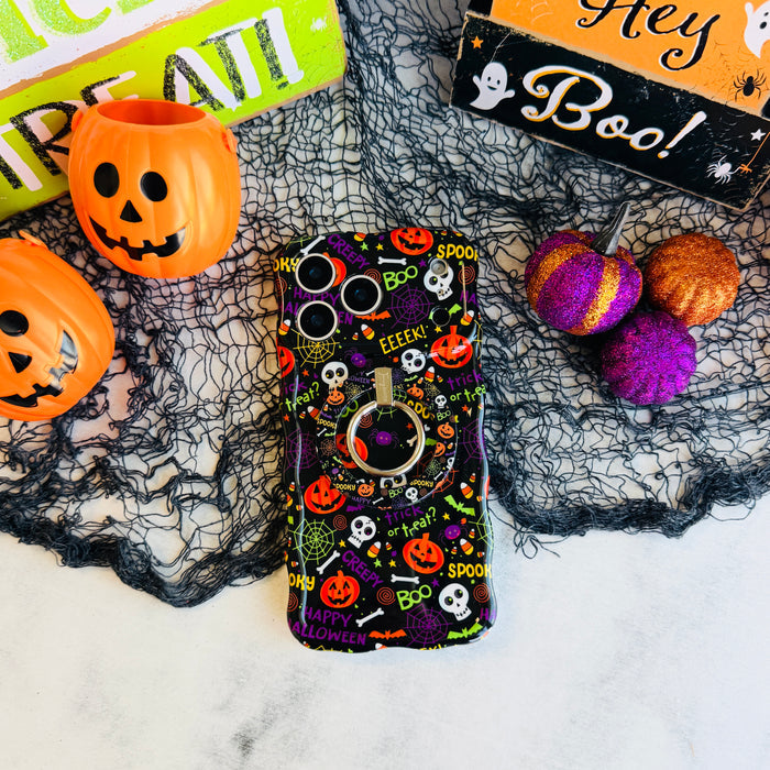 Spooky MagSafe grip ring attached to the matching Wavy Luxe case on black spiderweb mesh with an orange pail and a Hey Boo sign.