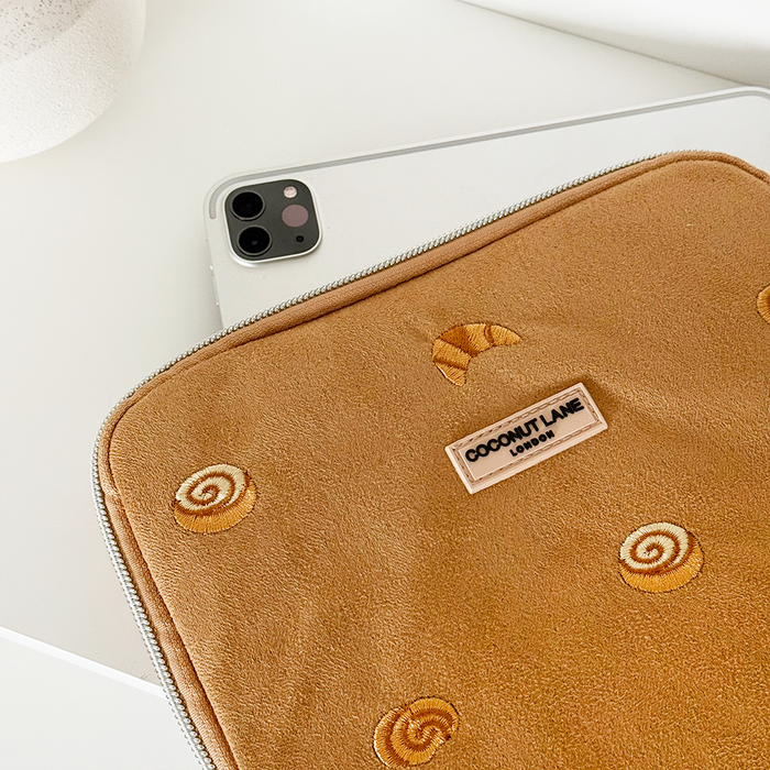 Suedette Croissant Club iPad sleeve in beige by Coconut Lane, partially covering a silver iPad on a white surface.