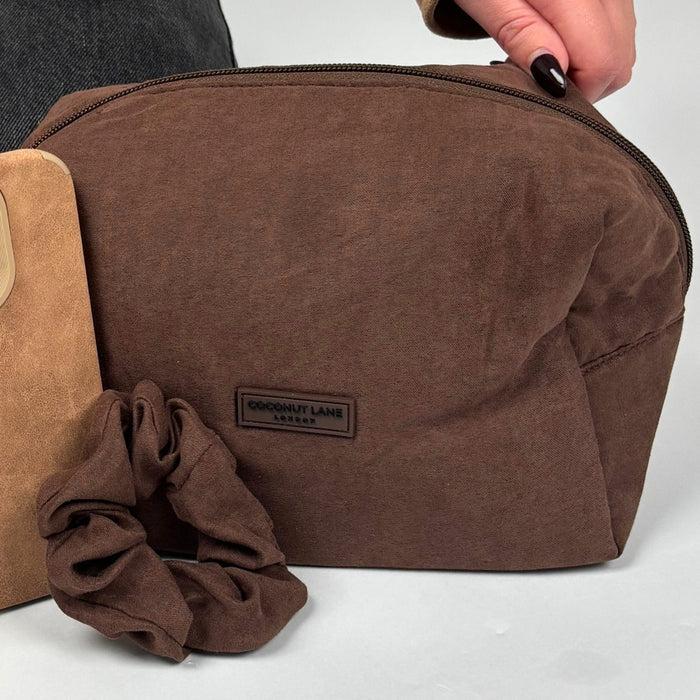 Chocolate brown suedette makeup bag with a matching scrunchie and a tan accessory beside it.