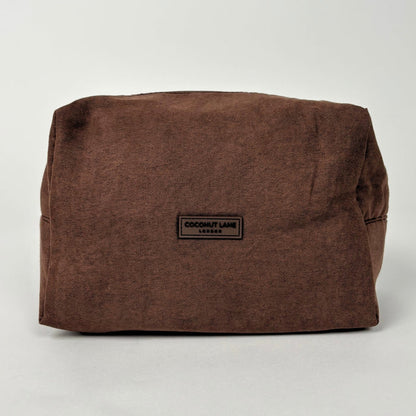 Chocolate brown suedette makeup bag with a black label, minimalist design by Coconut Lane.