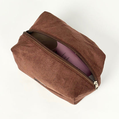 Chocolate Coconut Lane suedette makeup bag, partially open with a purple item inside, on a white background.