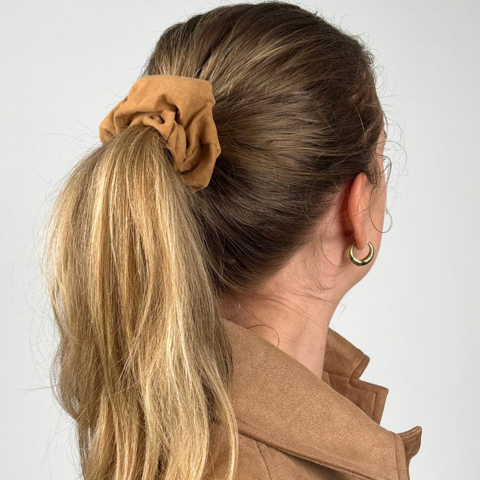 Tan suedette scrunchie by Coconut Lane securing a blonde ponytail, viewed from the back.