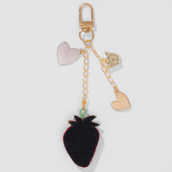 Cute strawberry bag charm with dangling hearts, butterfly detail and golden clip chain