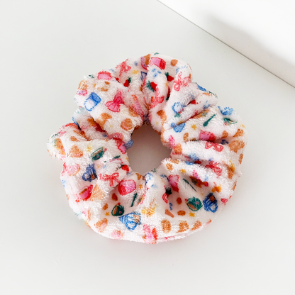 White towel scrunchie with bow detail and dotted pattern from Coconut Lane’s Breakfast Club collection.