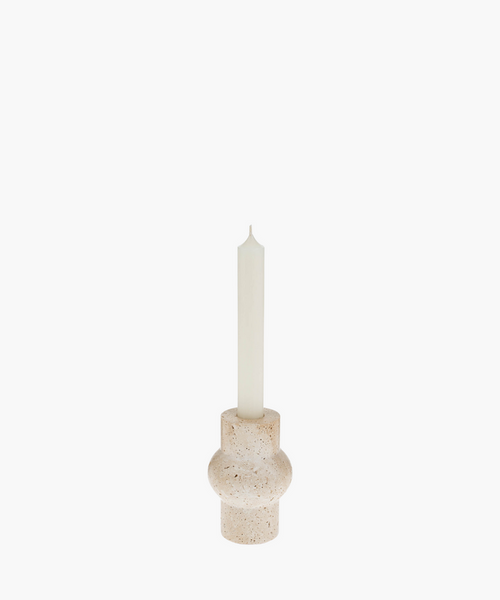 A tall white candle in a rounded, beige travertine stone holder with a textured surface. The minimalist design evokes a calm and serene atmosphere. | SW Home