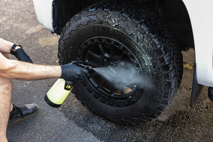 Person cleaning a tire with an iK Sprayer filled with P&S Undressed.