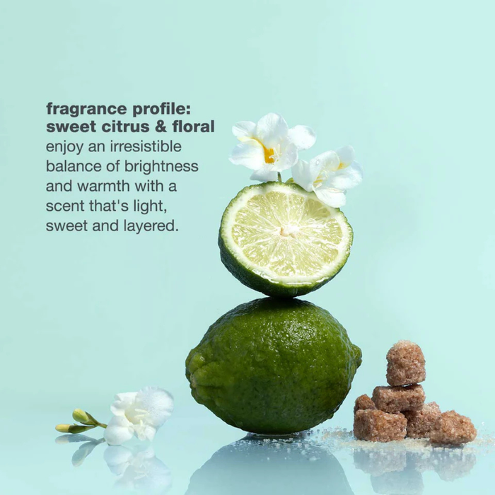 Two limes, one halved, with flowers on a light blue background