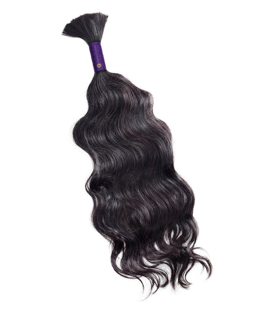 A bundle of long, wavy Perfect Locks Wavy Bulk Hair for Braiding in Natural Black , tied at the top with a purple band.
