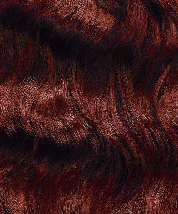 Close-up of wavy, shiny golden brown  hair with highlights and lowlights, enhanced with I-Tip extensions for texture and movement.#color_dark-auburn-(33)