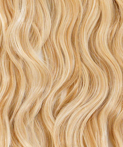 Close-up of long, wavy Chocolate Brown  hair with a shiny, healthy look. Smooth strands highlight Perfect Locks extensions.#color_caramel-blonde-highlights-(24/27/613)